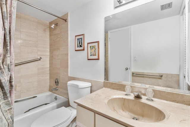 full bathroom with toilet, tiled shower / bath, tile walls, and vanity