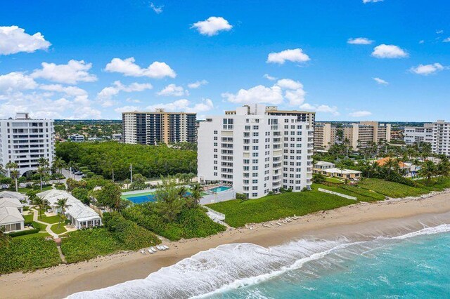 birds eye view of property with a water view and a beach view