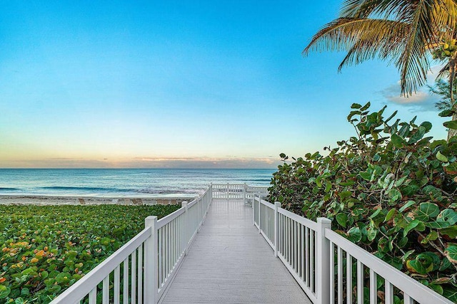 view of home's community with a water view and a beach view