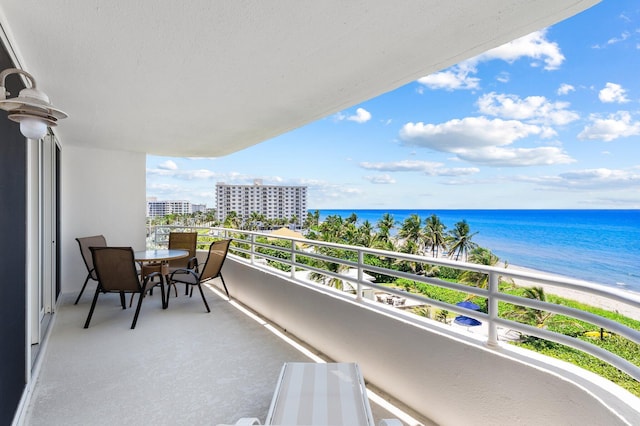 balcony featuring a view of the beach and a water view