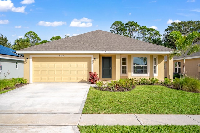 ranch-style house featuring a front yard and a garage