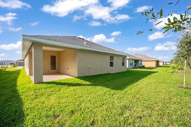 rear view of house with a patio and a lawn