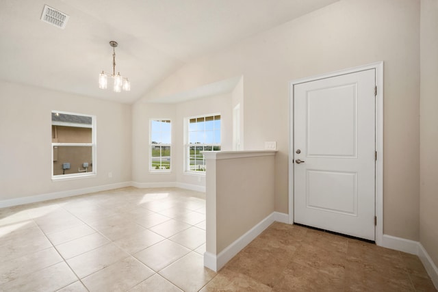 entryway with light tile patterned flooring, vaulted ceiling, and a notable chandelier