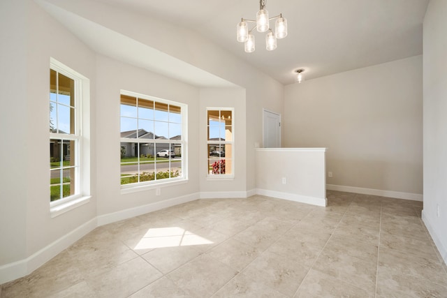 unfurnished room with a chandelier, light tile patterned floors, vaulted ceiling, and a wealth of natural light