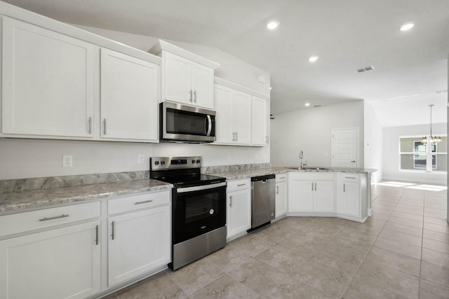 kitchen featuring white cabinetry, sink, kitchen peninsula, lofted ceiling, and appliances with stainless steel finishes