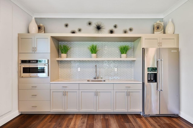 kitchen with appliances with stainless steel finishes, dark hardwood / wood-style flooring, crown molding, and sink