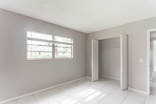 unfurnished bedroom with a closet and light tile patterned floors