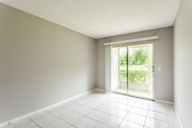 empty room featuring light tile patterned floors and a textured ceiling