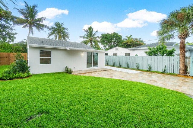 rear view of house featuring a patio area and a yard