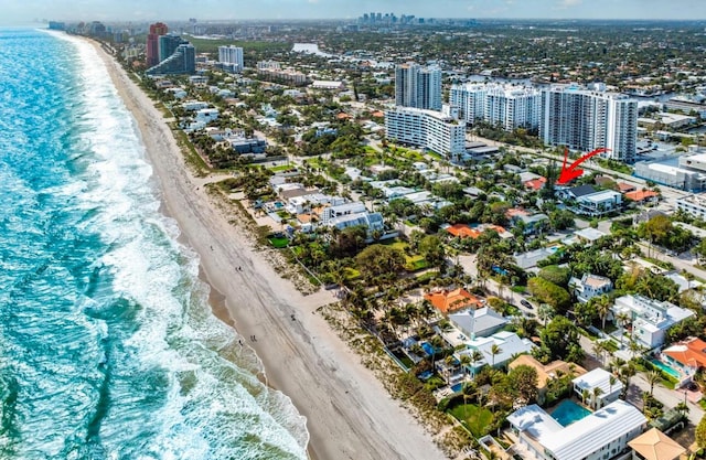 drone / aerial view featuring a water view and a beach view