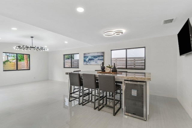 dining space featuring a notable chandelier and beverage cooler