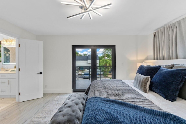 bedroom with ensuite bath, access to exterior, light hardwood / wood-style flooring, and multiple windows