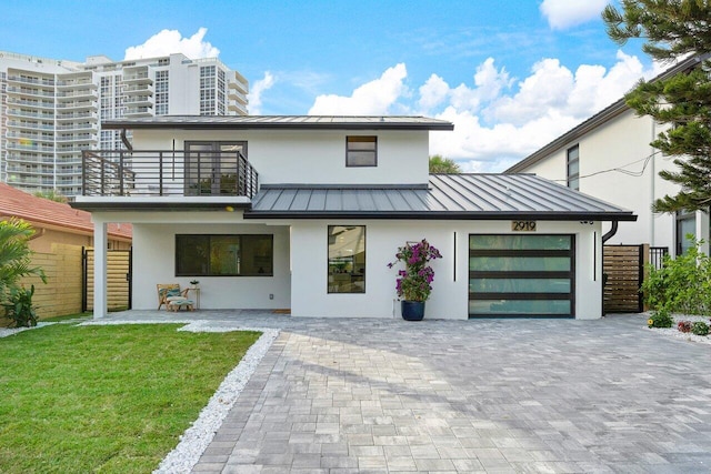 view of front of house featuring a balcony and a front lawn