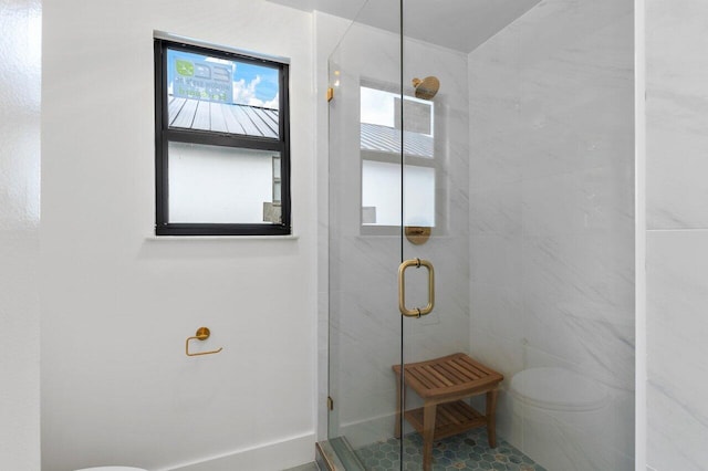 bathroom with a shower with door and toilet