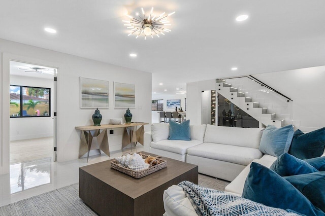 living room featuring ceiling fan with notable chandelier