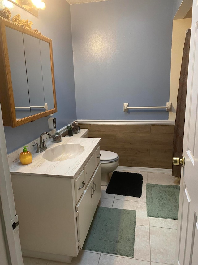 bathroom with tile flooring, toilet, and oversized vanity