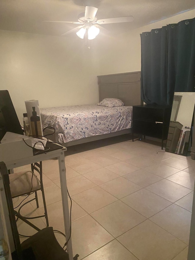 tiled bedroom featuring ceiling fan