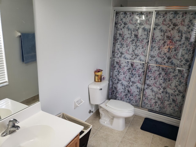 bathroom featuring tile patterned flooring, vanity, toilet, and walk in shower