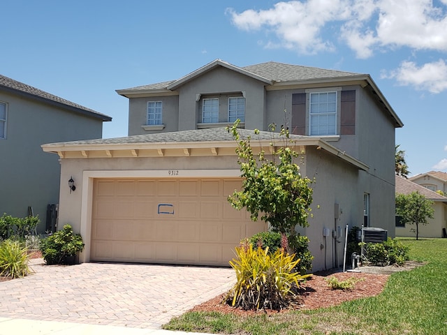 view of front of property featuring central air condition unit and a garage