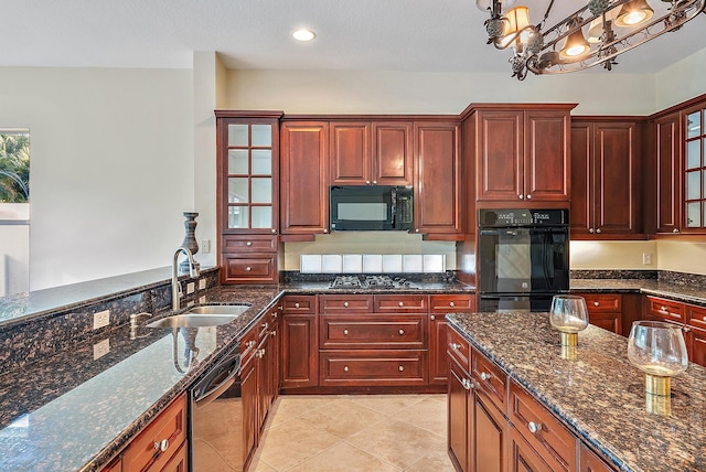 kitchen with sink, dark stone counters, decorative light fixtures, light tile patterned floors, and black appliances