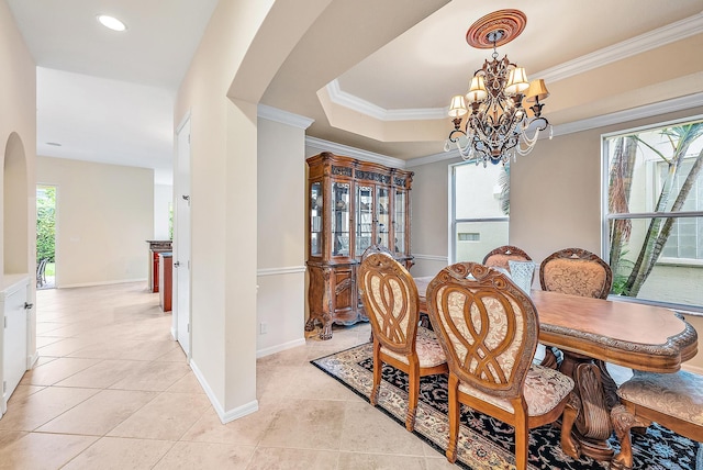 dining space featuring a healthy amount of sunlight, light tile patterned floors, a tray ceiling, and an inviting chandelier