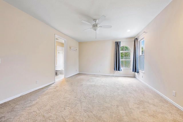 spare room featuring ceiling fan and light carpet