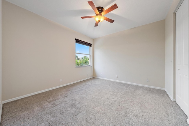 carpeted spare room featuring ceiling fan