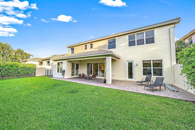 back of house featuring a patio area and a lawn