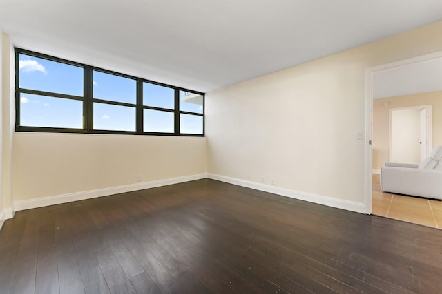 unfurnished room with dark hardwood / wood-style floors