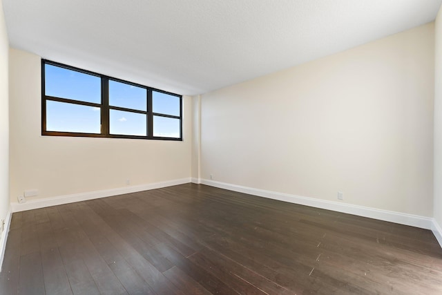 spare room with dark hardwood / wood-style floors