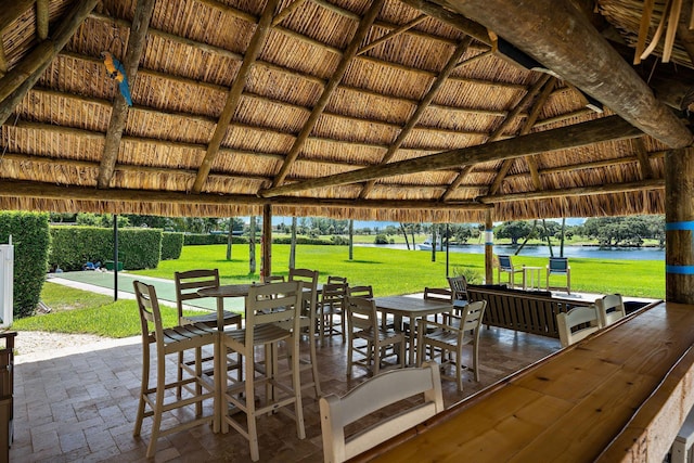 view of dock featuring a gazebo, a patio area, a yard, and a water view