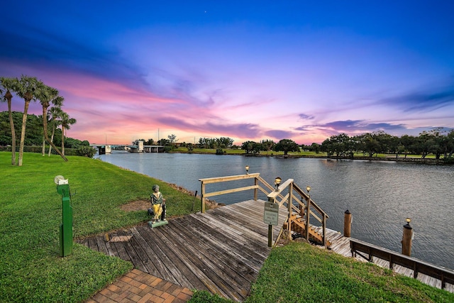 view of dock featuring a water view and a yard