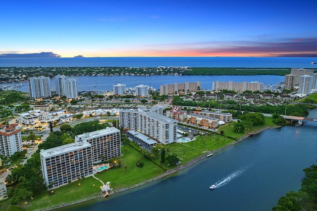 aerial view at dusk featuring a water view