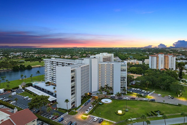 aerial view at dusk featuring a water view