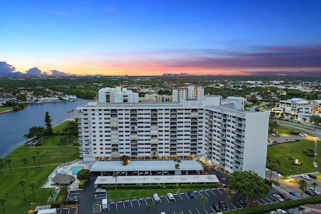 aerial view at dusk featuring a water view