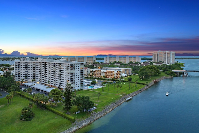 aerial view at dusk featuring a water view