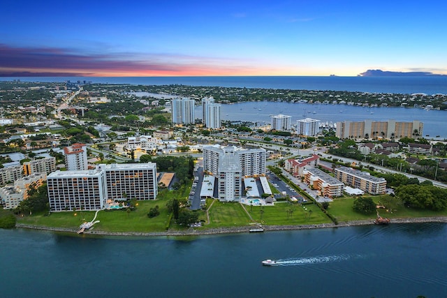 aerial view at dusk featuring a water view