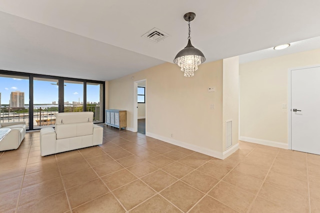 unfurnished living room with expansive windows, light tile patterned floors, and a chandelier