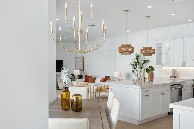 kitchen with crown molding, sink, white cabinets, and an island with sink