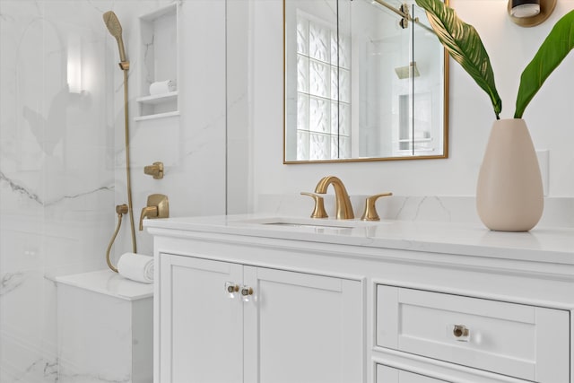 bathroom featuring a tile shower and vanity