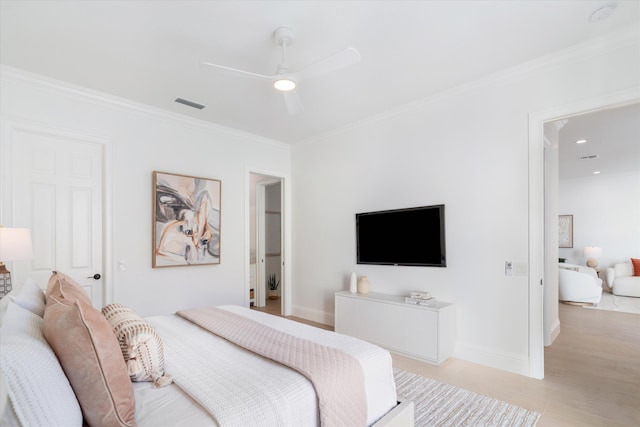 bedroom with ceiling fan, crown molding, and light hardwood / wood-style flooring