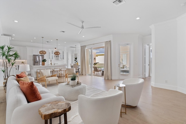 living room featuring ceiling fan, crown molding, and light hardwood / wood-style floors