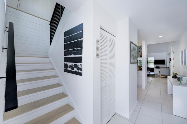 hallway featuring light tile patterned floors and washer / dryer