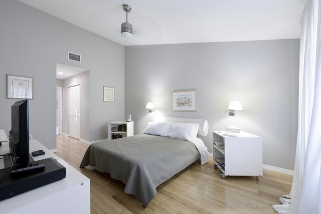 bedroom featuring a closet, ceiling fan, light hardwood / wood-style flooring, and lofted ceiling