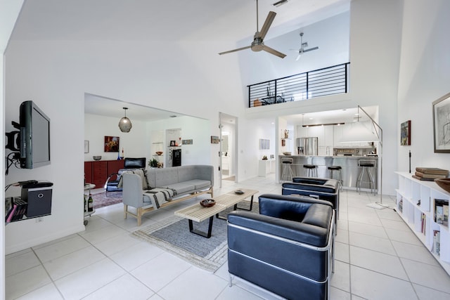 tiled living room with ceiling fan and a high ceiling