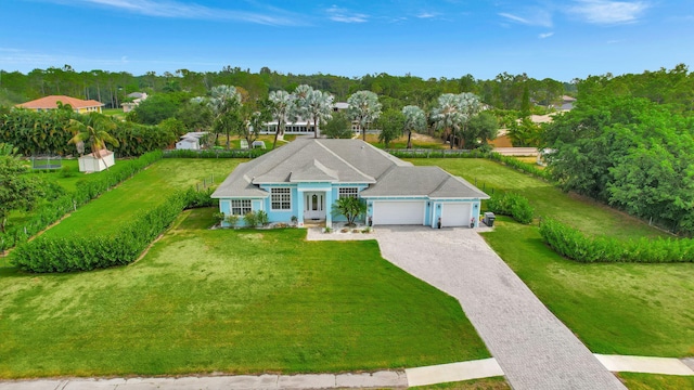 view of front facade with decorative driveway, an attached garage, and a front yard