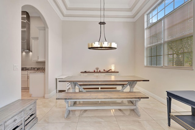 dining area with ornamental molding, arched walkways, light tile patterned flooring, and baseboards