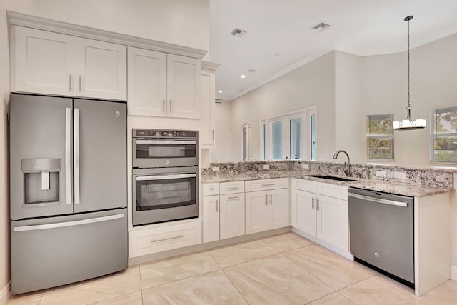 kitchen with pendant lighting, white cabinets, sink, light stone countertops, and stainless steel appliances