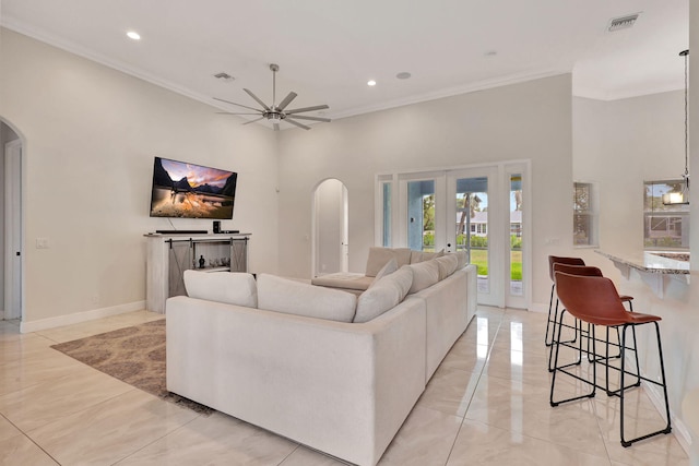 living room with french doors, ceiling fan, and crown molding