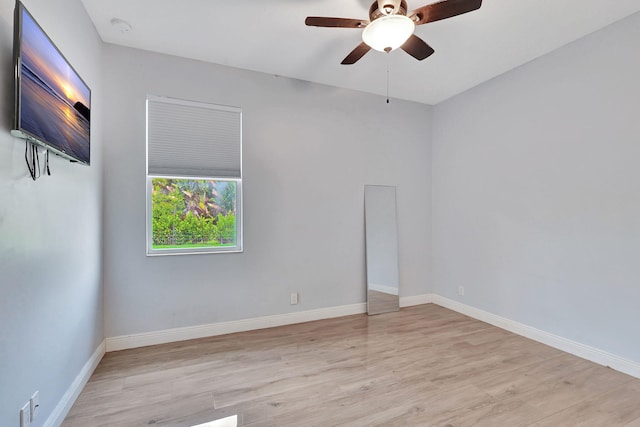 empty room featuring a ceiling fan, baseboards, and wood finished floors